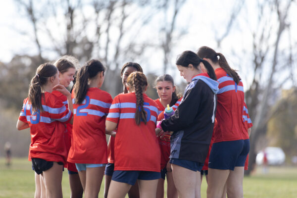Young women soccer players huddled together. 